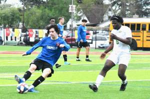 The Enumclaw High boys soccer team ended its regular season Friday night by hosting Clover Park. EHS used a pair of goals by Landon Breidenbach to hold a 2-1 lead into the games final stages. The Timberwolves scored twice in the waning minutes to escape with a 3-2 league victory. Pictured is Aiden Navarro sending a ball downfield while being pressured by Clover Parks Zarrwuo Mulbah (8). Photo by Kevin Hanson