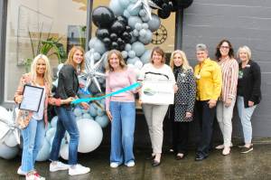 Chamber of Commerce Executive Director Kerry Solmonson, Rainier Foothills Wellness Foundation Executive Director Sara Stratton, Program Coordinator Deanna Kuzaro, Board Vice President Tammi Voorhees, Treasurer Pat Kollen, President Suzanne Lewis, Elaine Parks, and Becky Olness celebrate the nonprofits new location on Griffin Avenue with a ribbon cutting. Photo by Ray Miller-Still