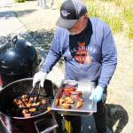 Rob Rapier checking on his sausages and chicken for the BBQ and Brew Fest event; his chicken garnered first place in the individual category at the competition. Photo by Ray Miller-Still