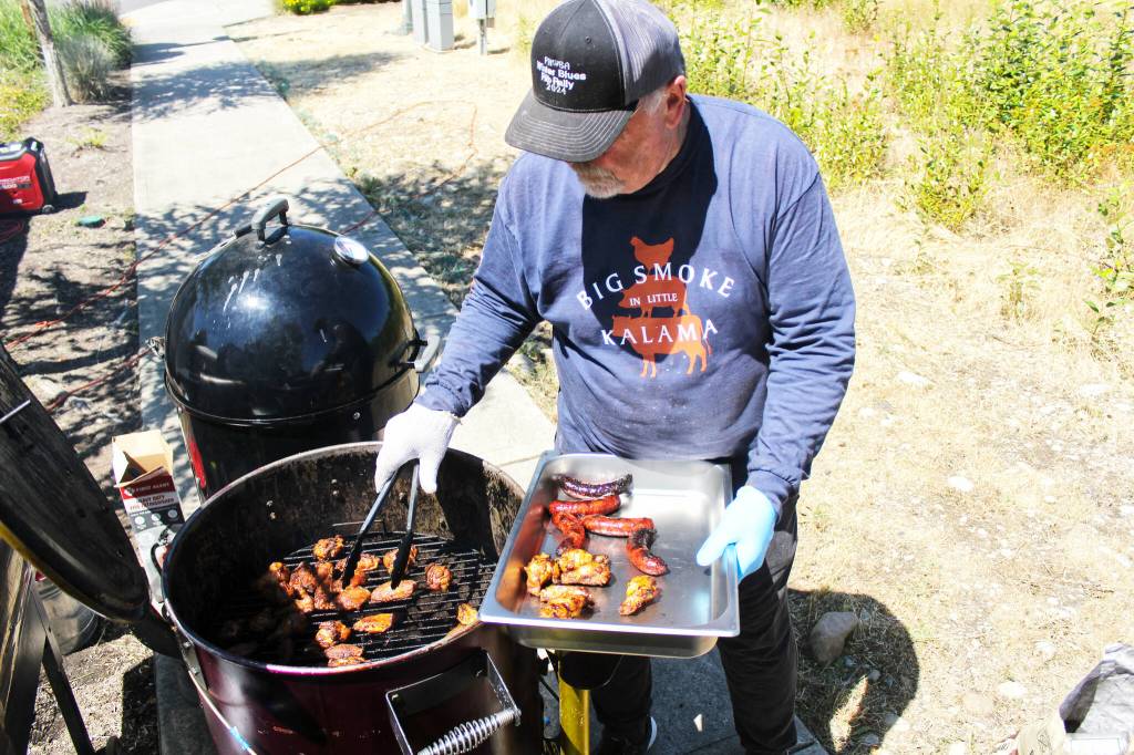 Rob Rapier checking on his sausages and chicken for the BBQ and Brew Fest event; his chicken garnered first place in the individual category at the competition. Photo by Ray Miller-Still