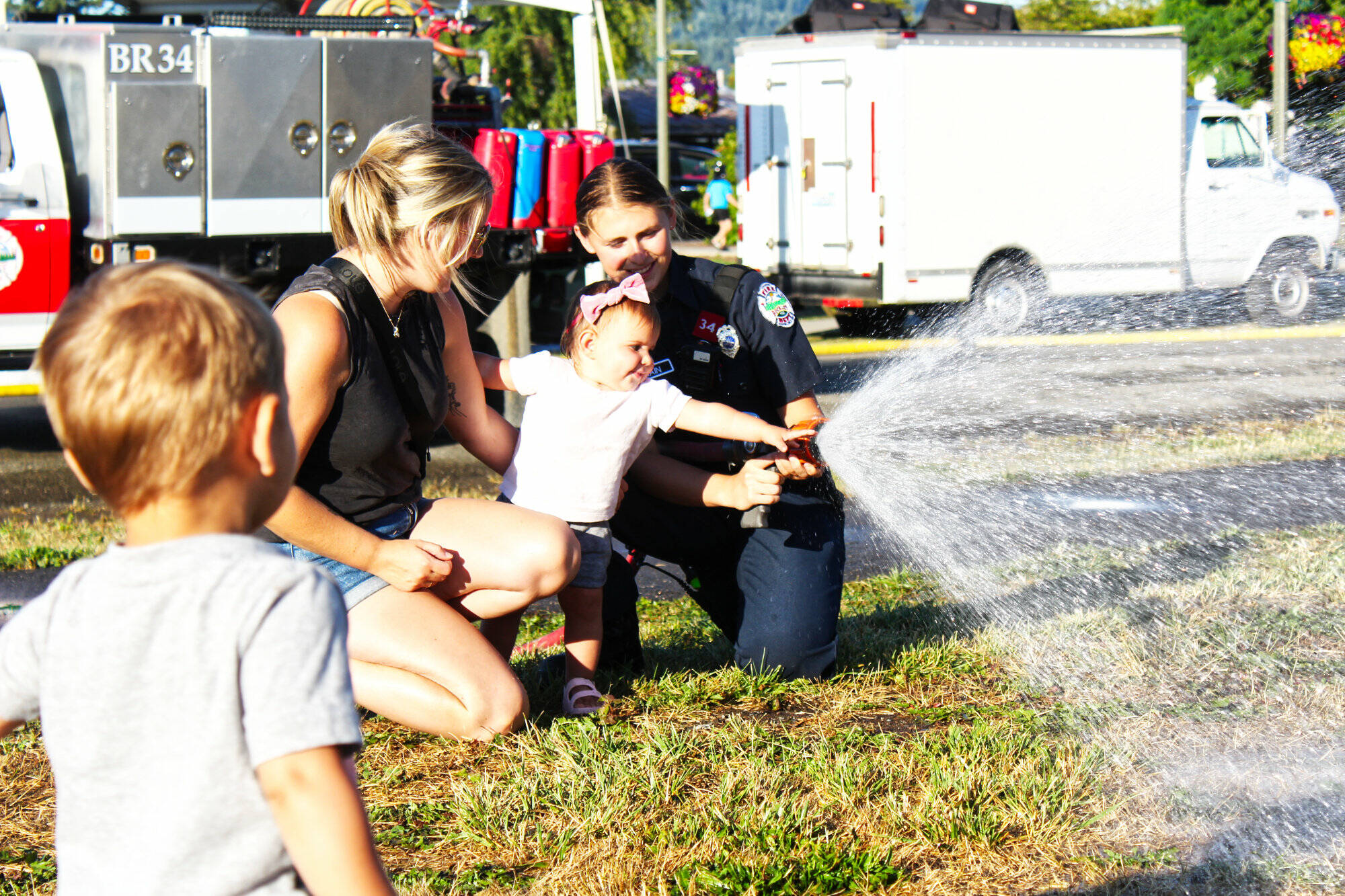 Photo by Ray Miller-Still
Myla Cannizzaro helping a Buckley firefighter with a hose for the splash zone during last years National Night Out event.