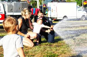 Photo by Ray Miller-Still
Myla Cannizzaro helping a Buckley firefighter with a hose for the splash zone during last years National Night Out event.