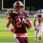 In the reflection of the scoreboard lights No. 24 Louis Chevalier scores another Enumclaw touchdown. Photo by Todd Overdorf / SonScape Images