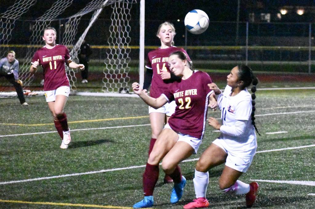 PHOTO BY KEVIN HANSON White River and Enumclaw High played back-to-back soccer games the evening of Nov. 7 at Harry Lang Stadium in Lakewood. At stake was a district victory and guaranteed berth into the Class 3A state tournament. Both squads fell in hard-fought games, setting up a Hornet-Hornet, Saturday night showdown for the districts seventh and final state entry. In this photo, a header by White Rivers Jordyn Daigle (22) keep play alive as teammates Riley Soule (14) and Belle Knauss move in.