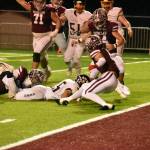 PHOTO BY KEVIN HANSON 
Pictured is a key play in Enumclaws Friday night whitewashing of the visiting Southridge Suns. The only time the Suns moved close to the end zone, the Hornets Cooper Rodarte wrapped up the legs of the Southridge ballcarrier on fourth down, giving EHS the ball.