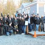 Volunteers and employees with Operation Tiny Home, Building Beyond the Walls, the Roots Collective, and other organizations celebrating Mike Lane's new home, which was still receiving finishing touches as speeches were given. Photo by Ray Miller-Still