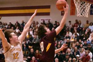 PHOTO BY KEVIN HANSON
Enumclaw Highs Gavin Trachte goes high for a layin during Friday nights victory over visiting White River. Applying defensive pressure is Zach Wisdom (12).