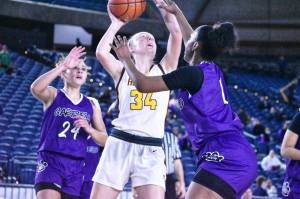 Photo by Kevin Hanson
Vivian Kingston (#34), sandwiched between Garfield defenders, puts up a shot during White Rivers state tournament game in the Tacoma Dome. The senior ended her Hornet career with a flourish, scoring 12 points and pulling down 16 rebounds.