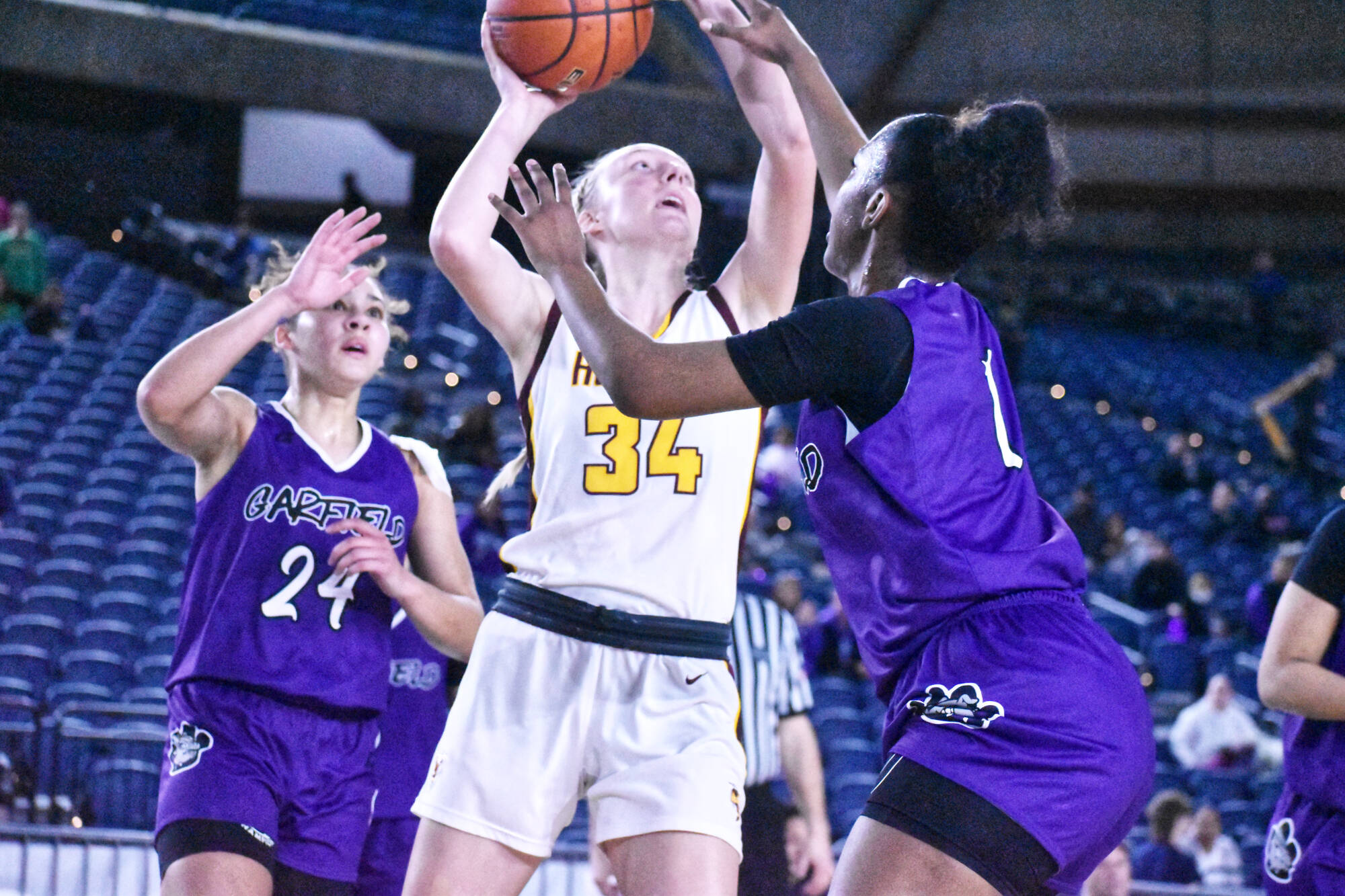 Vivian Kingston (#34), sandwiched between Garfield defenders, puts up a shot during White Rivers state tournament game in the Tacoma Dome. The senior ended her Hornet career with a flourish, scoring 12 points and pulling down 16 rebounds. Photo by Kevin Hanson