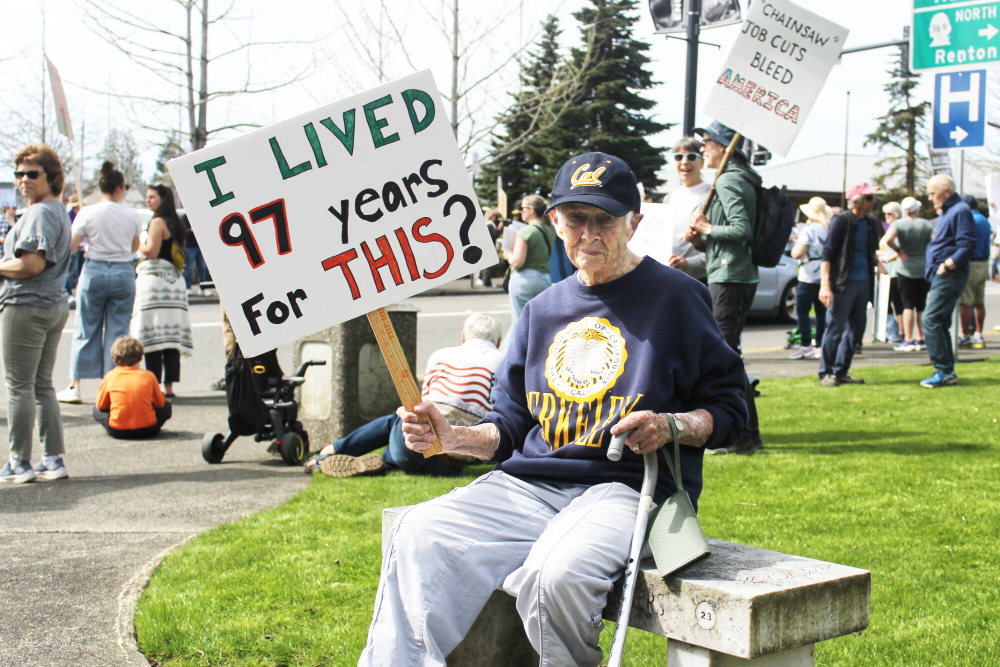 Chants of "Hands off" and "This is what democracy looks like" dominated the corner of Porter Street and Griffin Avenue last Saturday between noon and 2 p.m. Among the protestors was Dore Aitken, 97, who believes that public funds for children and seniors is not government waste. Photo b