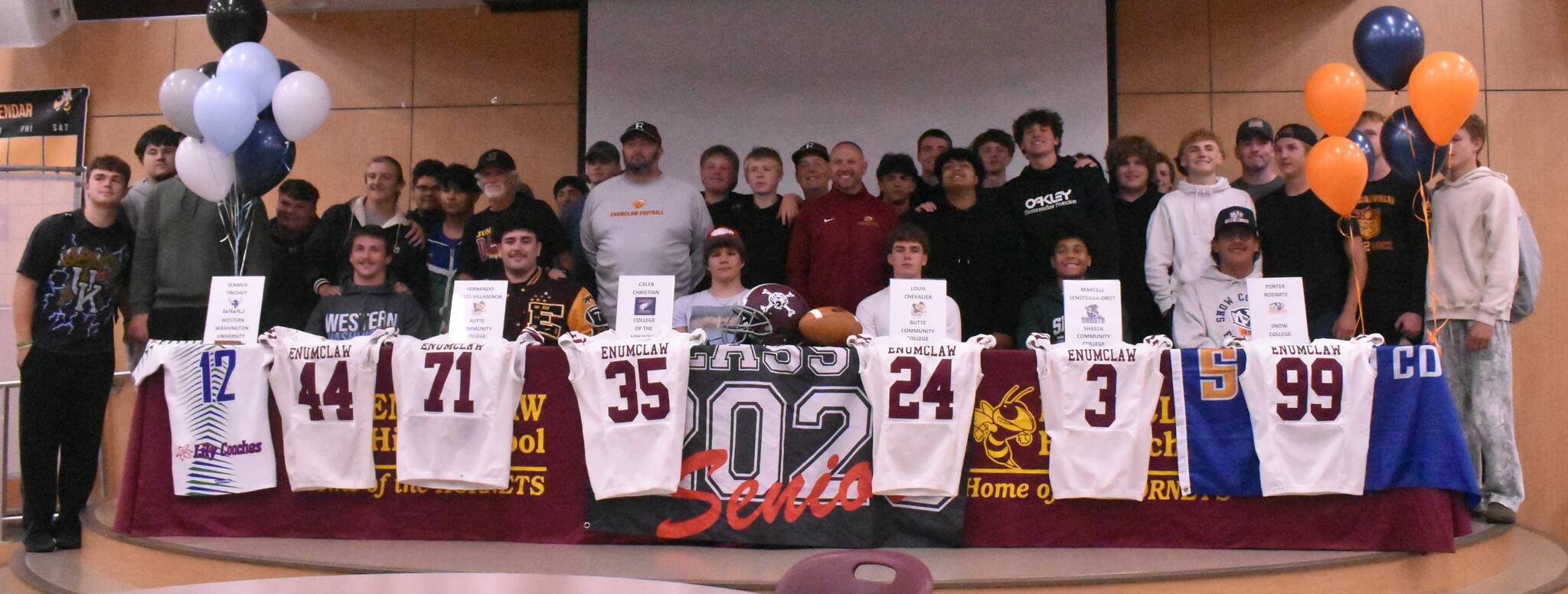 PHOTO BY KEVIN HANSON Enumclaw High athletes, joined by teammates and coaches, signed last week with collegiate programs. Seated, from left, are Seamus Twohey, Fernando Reyes Villasenor, Caleb Christian, Louis Chevalier, Marcell Lensegrav-Obot and Porter Rodarte.