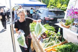 Farmer Lauren of Enumclaw Farm is only one of many local farmers, crafters, and bakers that set up shop at the Enumclaw Plateau Farmers Market. Photo by Ray Miller-Still