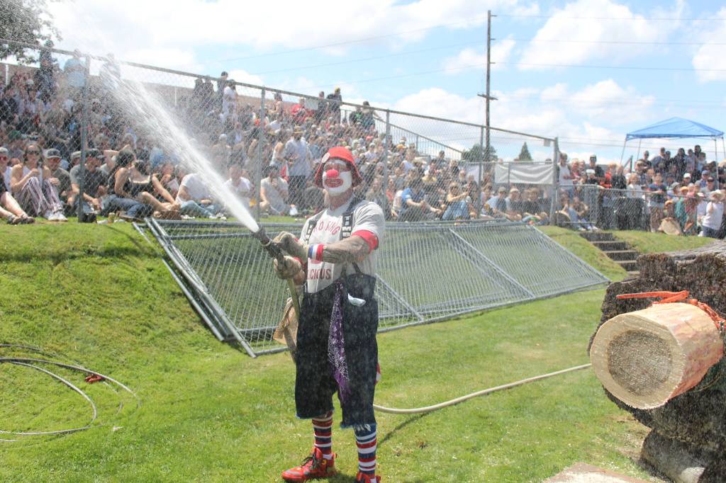 Photo by Ray Miller-Still 
Theres no protection from the sun down there in the pits. Thankfully, Log Show clown Timbrr, occasionally breaks out the fire hose to cool down the audience.
