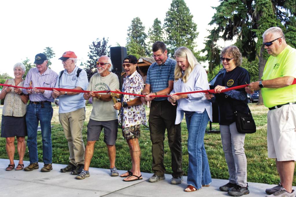 Members of the Foothills Rails to Trails Coalition and other supporters of the Foothills Trail cutting the ribbon on Aug. 7. Each person got to keep a piece of the ribbon as memorabilia. Photo by Ray Miller-Still