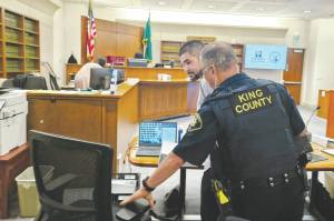 Photo by Ray Miller-Still
Andrew Baim being led out of court after opening statements concluded.