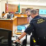 Andrew Baim being led out of court after opening statements concluded. Photo by Ray Miller-Still