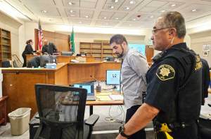 Black Diamond resident Andrew Baim being led out of the courtroom after the jury started deliberating his verdict. Photo by Ray Miller-Still