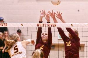 White River's Emery Stevenson (5) sends a spike over the outstretched arms of EHS blockers Kaylee Wall (2) and Halle Martel (12). Also, Enumclaw's Haley Dumontet (3) sets up a teammate for a play at the net.