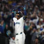 Julio Rodriguez raises his arms after scoring on a home run. Photo credit: Ben Van Houten / Seattle Mariners