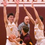 Enumclaws Kannon Kuzaro (#4) drives to the hoop during his teams January 8 victory, getting pressure from White Rivers Ben Berg.