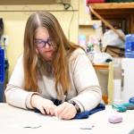 Cheyenne Loveland, a volunteer with Plateau Outreach Ministries, labels clothes with prices before they go onto the main floor. Photo by Ray Miller-Still