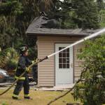Photo by Allyson Ballard. A firefighter from Central Whidbey Island Fire and Rescue sprayed the neighboring home.